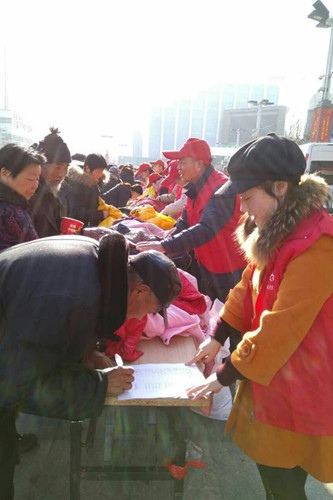 08河南濮阳志愿者为务工返乡的农民工发放棉衣