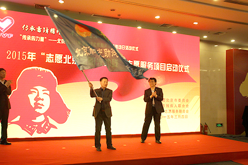 新保主任为助残志愿服务总队授旗