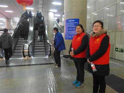 志愿者在电梯口提醒旅客注意乘梯安全