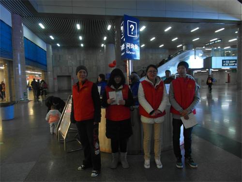 志愿者在问讯处服务为旅客提供问询服务