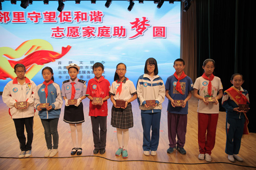2-与会领导为丰台区中小学生代表颁发《志愿服务户口簿》
