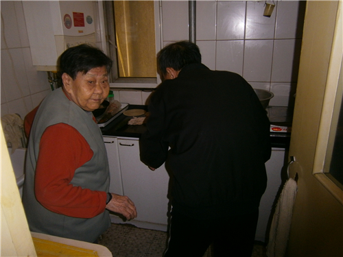 王主任在为陈大妈检查燃气灶故障原因P4030780