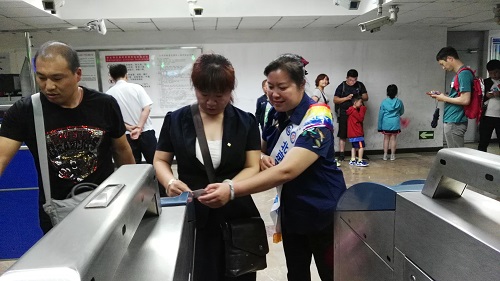 志愿者帮助乘客进站