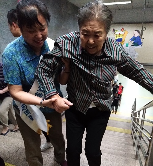 志愿者帮助行动不便的乘客出站