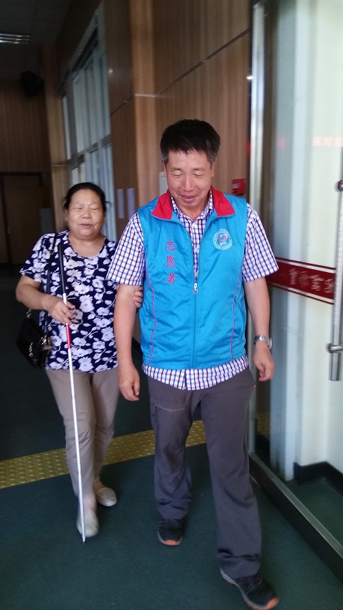 志愿者引领盲人朋友行走