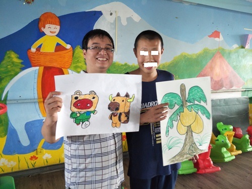 志愿者和孩子展示作品