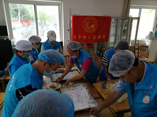 志愿者认真的包饺子