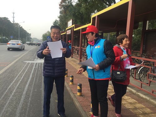 1志愿者向居民发放承诺书和宣传材料