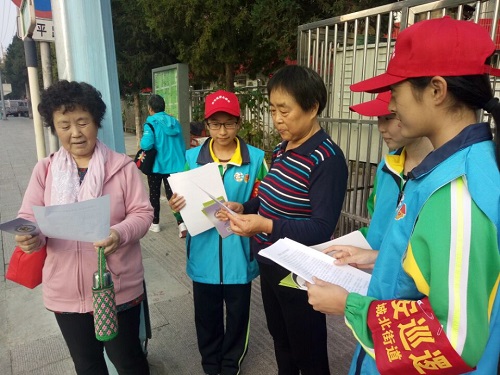 2志愿者向居民发放承诺书和宣传材料