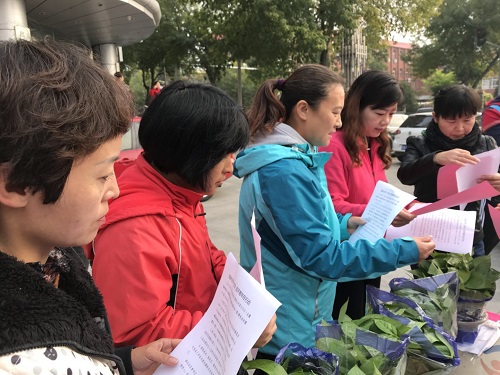 3志愿者向居民发放承诺书和宣传材料