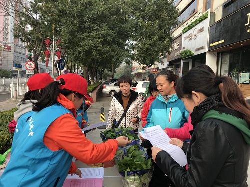 4志愿者向居民发放承诺书和宣传材料