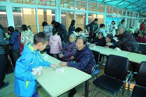 小志愿者为老人送上慰问品