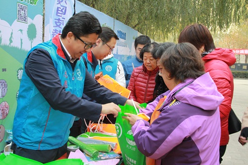 团市委副书记毛晓刚为居民发放垃圾分类宣传品