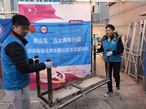 团市委驻点干部搬运废旧桌椅