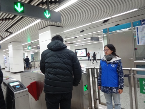 4志愿者引导乘客刷卡