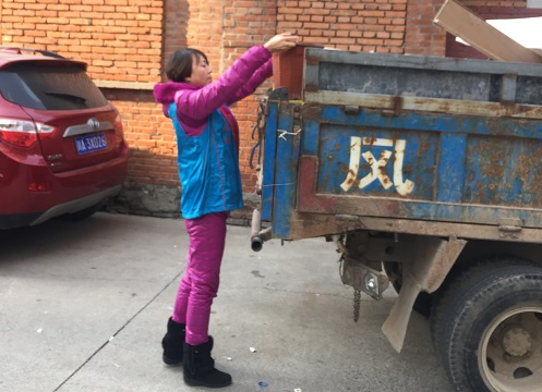 社区志愿者把清理的杂物搬上车