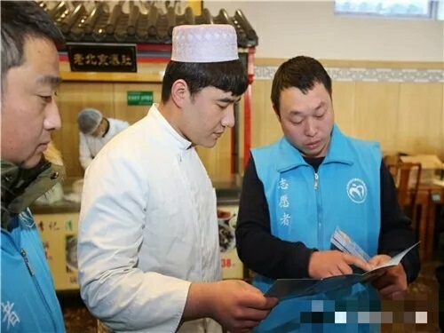 2城管志愿者为餐厅工作人员细心讲解