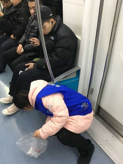 1-志愿者捡拾地铁车厢内的垃圾