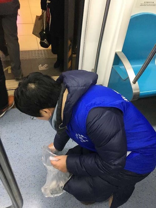 3-志愿者捡拾地铁车厢内的垃圾