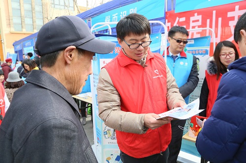 7-志愿者向群众宣传仿假币知识