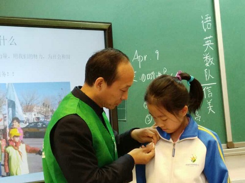 6-公益讲师为同学代表佩戴学雷锋志愿服务徽章