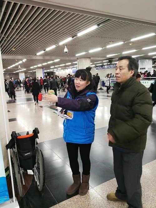 1 志愿者在北京西站为旅客指路