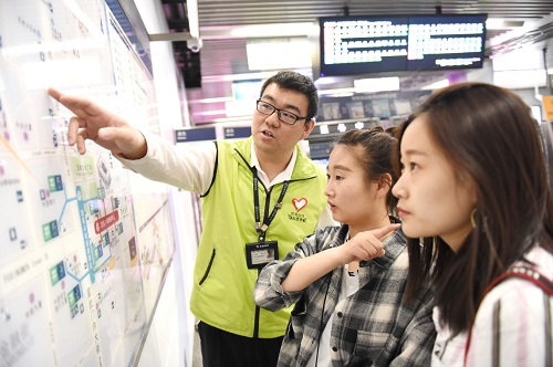2-志愿者在站厅向乘客指引出行线路
