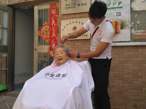 志愿者为老奶奶理发