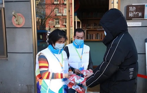 2.冬奥城市志愿者为市民指路并送上红色资源导览图