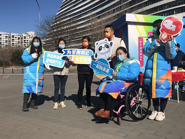 李楠在志愿者服务站点和大学生志愿者及市民合影