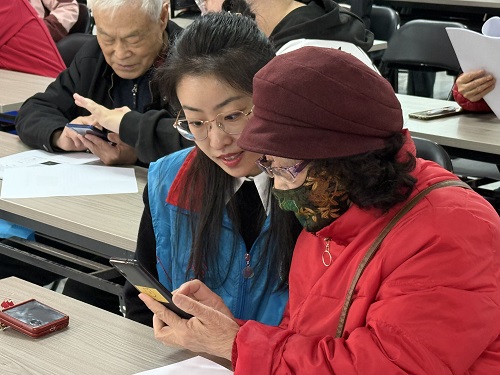 1-北京航天长征飞行棋研究所志愿者耐心为社区老人讲解如何下载安装水印相机