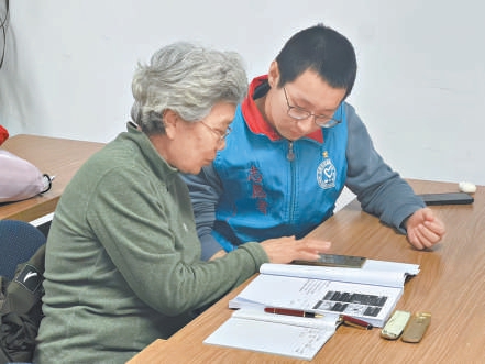 刘国豪教老人使用手机。