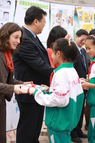 与会嘉宾向行知实验学校学生代表们赠送联合国开发计划署（UNDP）环保卡通书