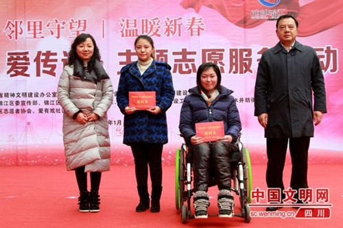 参会领导向成都市获得2016年度省十大最美志愿者称号的代表雷益群（右二）、钟蓓（左二）赠送新春慰问礼品。