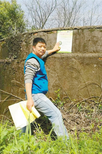 04毛建伟在湘潭法华山张贴爱鸟宣传海报。