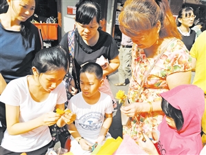 志愿者教市民手工制作。记者孙衍玲 摄