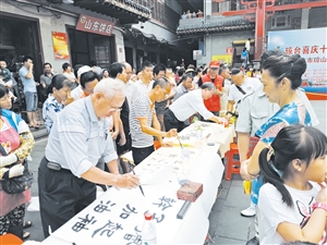 志愿者现场挥墨赠送市民。记者孙衍玲 摄
