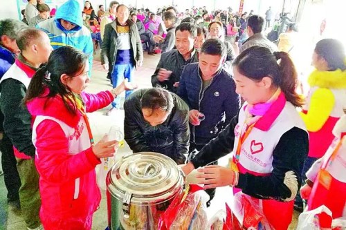 在惠州火车站志愿者为旅客送上热腾腾的红糖姜茶。图片来源：东江时报 记者骆国红