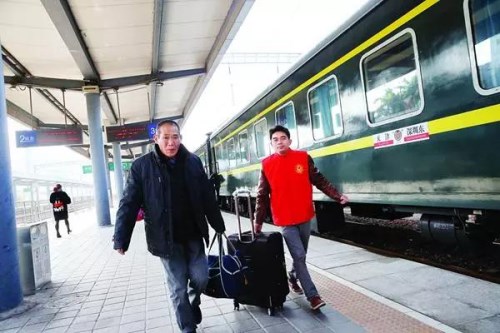 志愿者在惠州火车站帮助旅客乘车。 图片来源：惠州日报 记者钟畅新