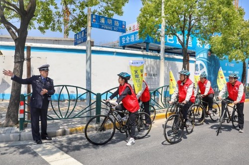 图说：志愿者深入周边道路宣传文明交通