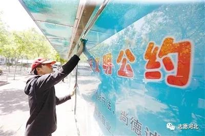 03志愿者在擦拭社区公告栏