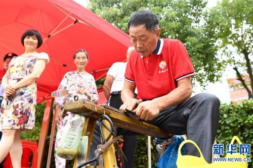 01肥西县上派镇肥光社区志愿者在为社区居民开展磨剪刀服务 新华社记者 刘军喜 摄