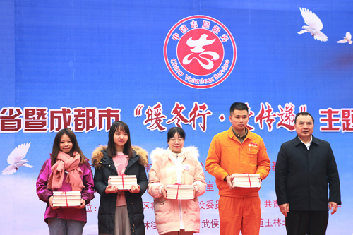 与会嘉宾为2018年度四川省志愿服务先进典型代表发放新年慰问物资。
