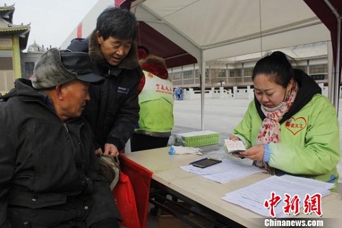 义工现场核实慰问对象信息。　李佩珊 摄