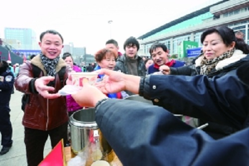 志愿者在贵阳火车站为旅客提供免费八宝粥、姜汤。 　　本报记者 石照昌 摄