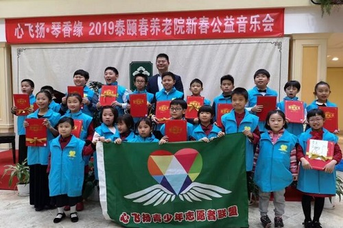泰颐春养老中心刘院长给孩子们颁发证书并合影。图片来源：琴香缘爱乐社