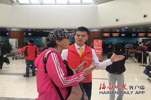美兰机场志愿者为游客进行引导。
