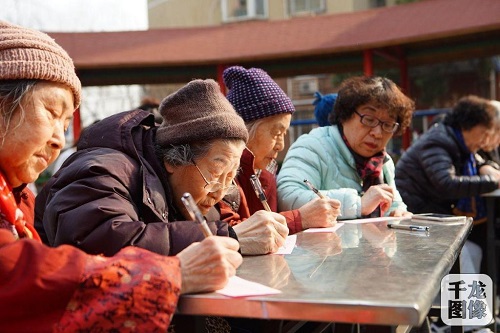 西城团区委举办“青春伴读”活动。图为青年志愿者走进社区，与老人一起阅读，老人认真记笔记。李波摄 千龙网发