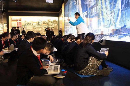 北京市五星级志愿者蒋巍在给学生讲解。蒋巍是春秋国旅的一名员工，从2015年起，每周利用业余时间来馆服务，讲解风格激情四射，对抗战史兴趣浓厚。